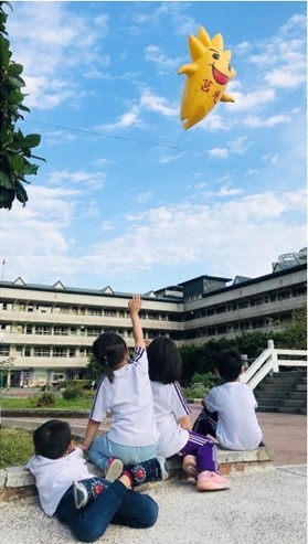 幼兒園小朋友在看飄在天空的莒光小子